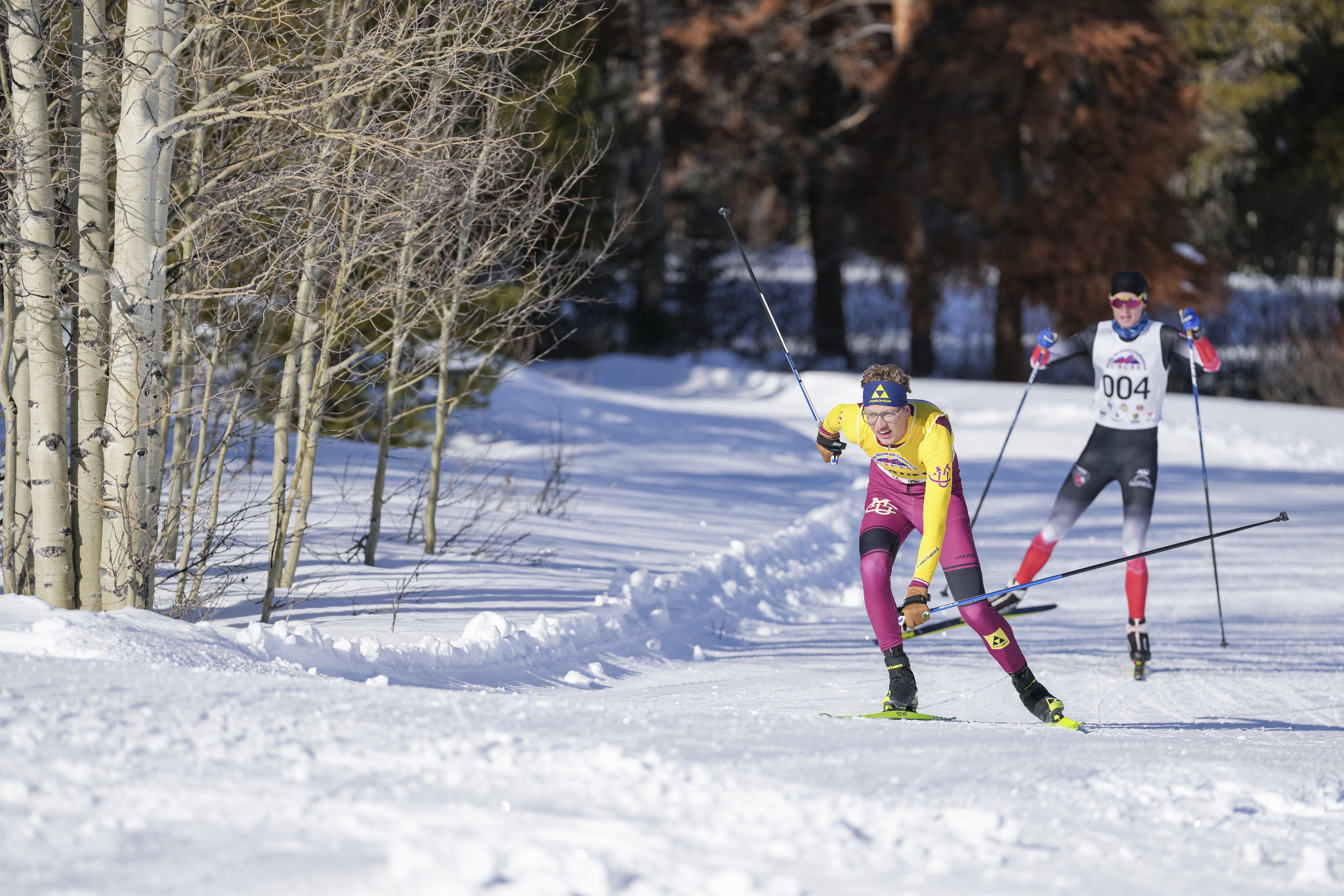 CMU athlete racing on a cross country ski trail through the forest